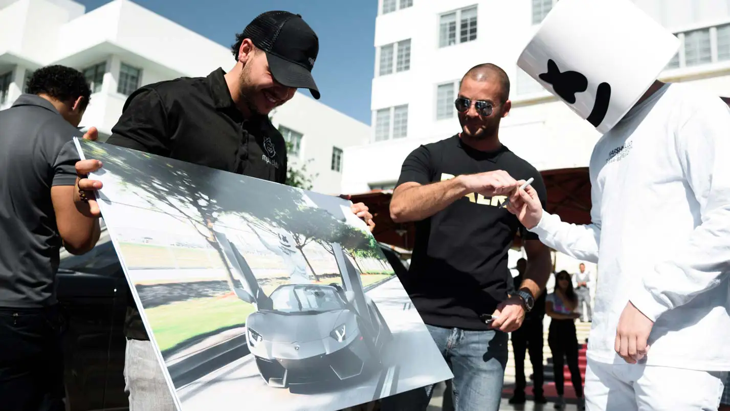 marshmello signing a picture for liram sustiel lamborghini aventador rental mph club exotic car rentals
