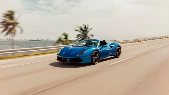 Blue Ferrari 488 Spider rental driving view mph club