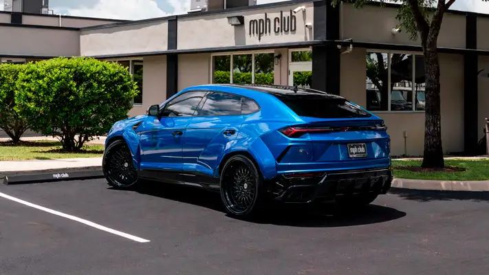 Lite blue Lamborghini Urus rental rear view mph club