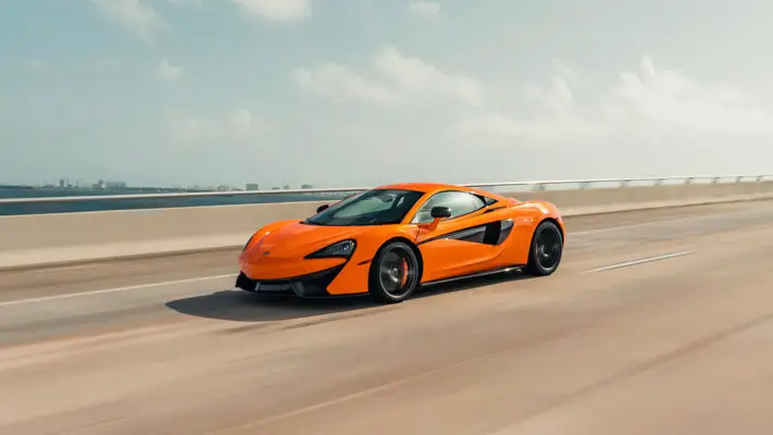 Orange McLaren 570s rental driving view mph club
