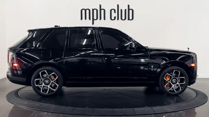Black on orange 4 seater Rolls Royce Cullinan Black Badge rental side view turntable mph club