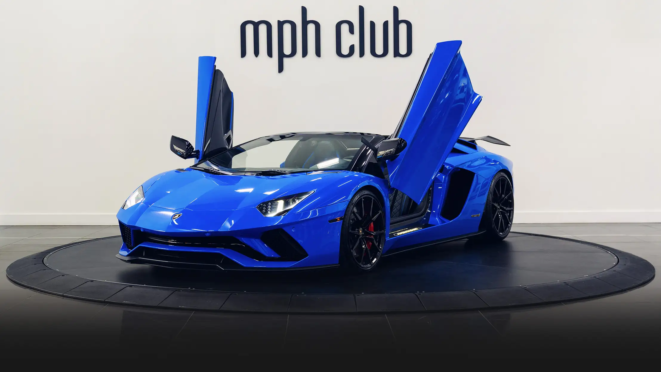 Blue on black Lamborghini Aventador S Roadster for rent profile view doors open turntable - mph club