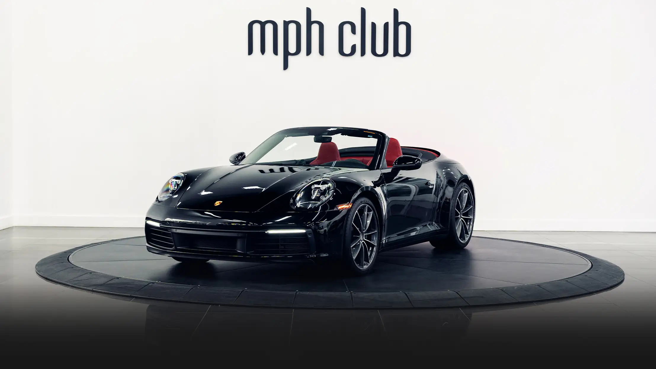 Black Porsche 911 Carrera Cabriolet rental profile view - mph club